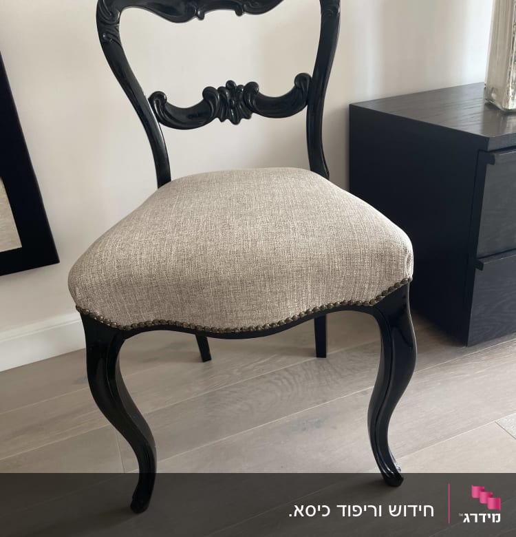 כיסא עם ריפוד בד בהיר ורגליים מעוצבות